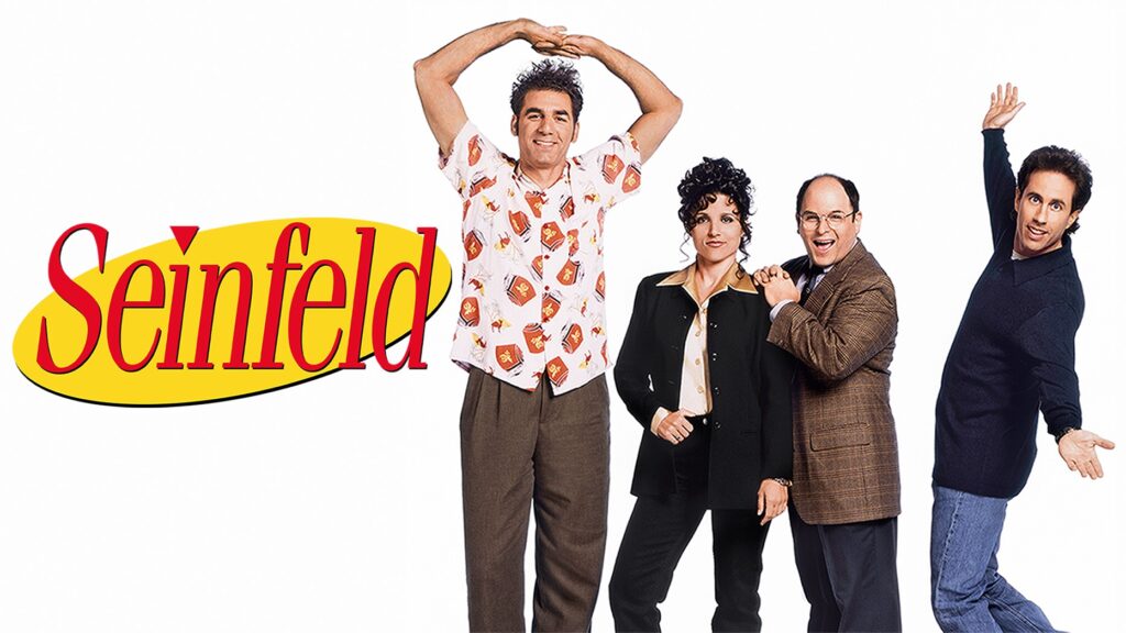 10 Insanely Popular TV Shows From the ‘90s You Can Stream on Netflix 1 Classic Seinfeld promotional photo showing the main cast of four - Jerry, Elaine, George, and Kramer - in their signature '90s outfits against a white background with the show's logo.
