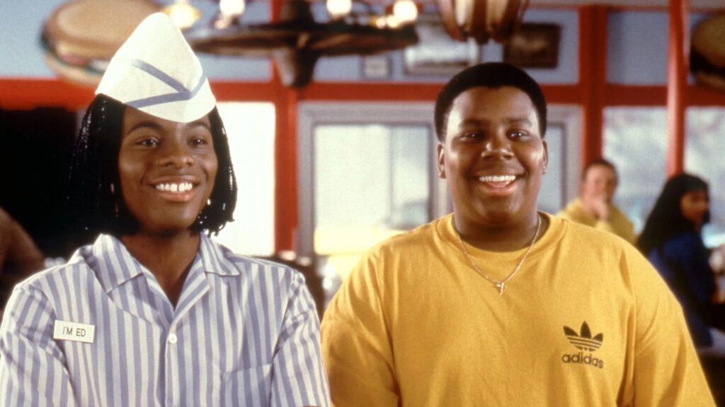 10 Insanely Popular TV Shows From the ‘90s You Can Stream on Netflix 10 Kenan and Kel in their Good Burger movie costumes - one wearing the classic striped Good Burger employee uniform with hat, both smiling at the camera in the restaurant setting.