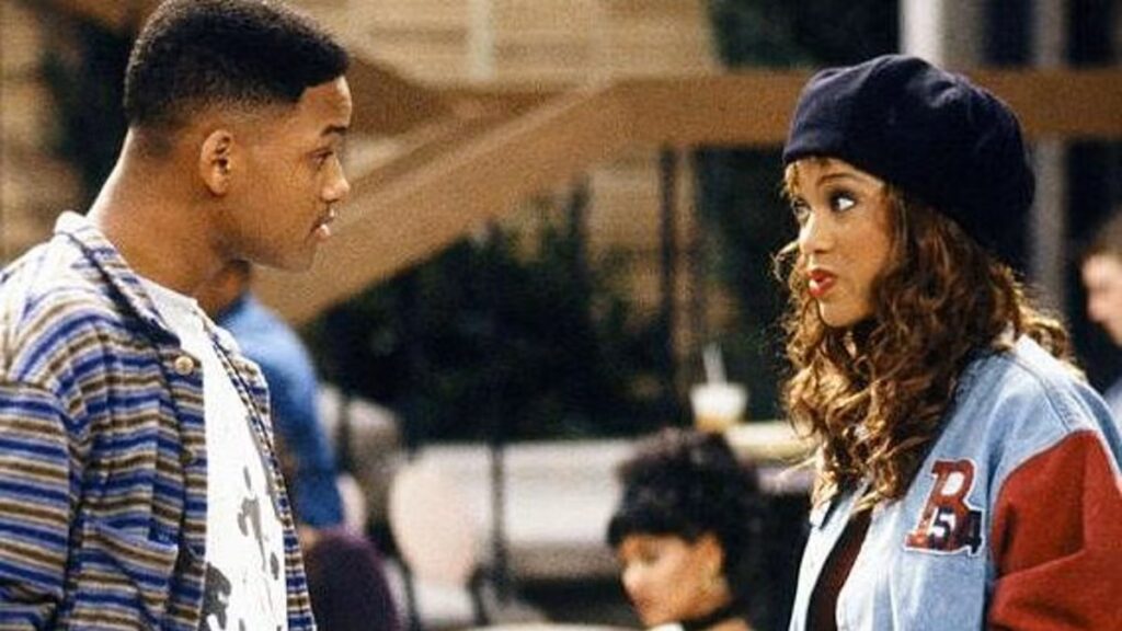 10 Insanely Popular TV Shows From the ‘90s You Can Stream on Netflix 14 Scene from The Fresh Prince of Bel-Air showing Will in a plaid shirt having a conversation with Tyra Banks wearing a black beret and denim jacket.