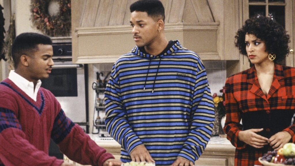 10 Insanely Popular TV Shows From the ‘90s You Can Stream on Netflix 12 Scene from The Fresh Prince of Bel-Air showing three characters in the Banks family kitchen, with Will in a striped hoodie speaking to Carlton and Hilary.