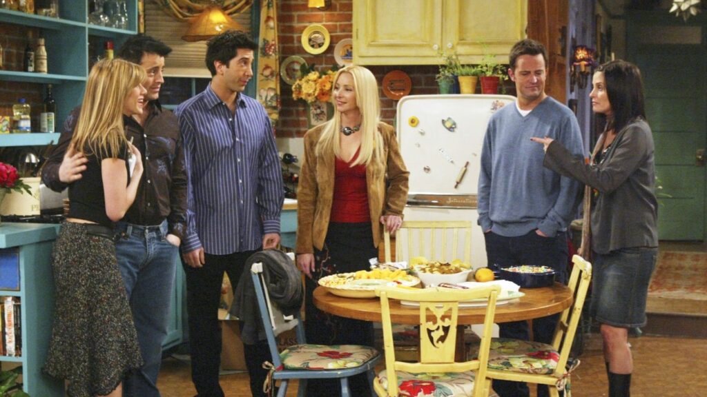 10 Insanely Popular TV Shows From the ‘90s You Can Stream on Netflix 19 Friends scene showing all six main characters,Rachel, Joey, Ross, Phoebe, Chandler, and Monica, gathered in Monica's kitchen during the show's finale.