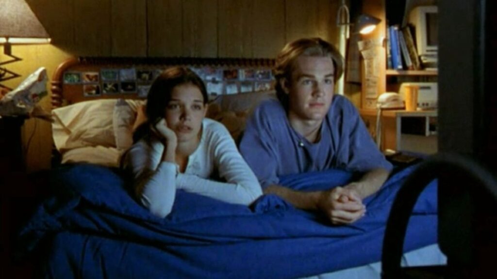 10 Insanely Popular TV Shows From the ‘90s You Can Stream on Netflix 22 Scene from Dawson's Creek showing Dawson Leery and Joey Potter lying in bed together in a bedroom setting.
