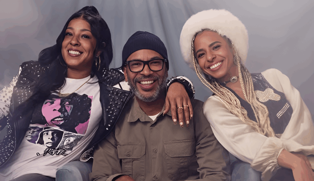Sly Stone Dies at 82: What We Know About His Wife, Family, and Net Worth 4 Sylvette "Phunne" Robinson, Sylvester Stewart Jr., and Novena Carmel posing together for a photo, all smiling at the camera.
