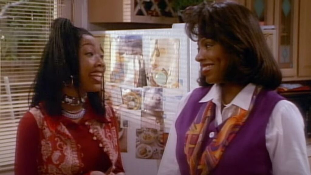 10 Insanely Popular TV Shows From the ‘90s You Can Stream on Netflix 33 Scene from "Moesha" featuring Moesha and Dee in conversation in a kitchen setting, Moesha wearing a red patterned top and Dee in a purple and white outfit.