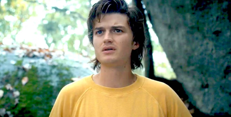 How Old Is ‘Stranger Things’ Cast: Actors’ Age in Season 1 and Season 5 6 Steve Harrington has a slightly messy hair and is wearing a yellow t-shirt. He is looking at someone with a concerned expression.