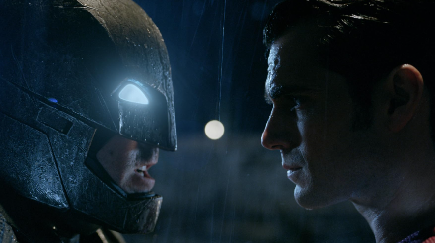 Batman is in his armored suit with glowing eyes. He faces off with Superman, who has a serious expression.