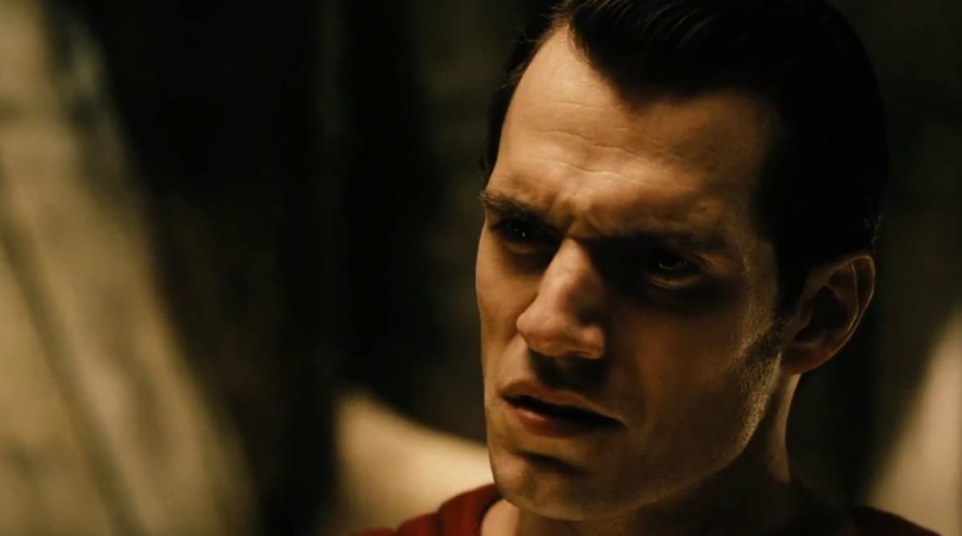A close-up of Superman's face shows him with a serious, almost pained expression.