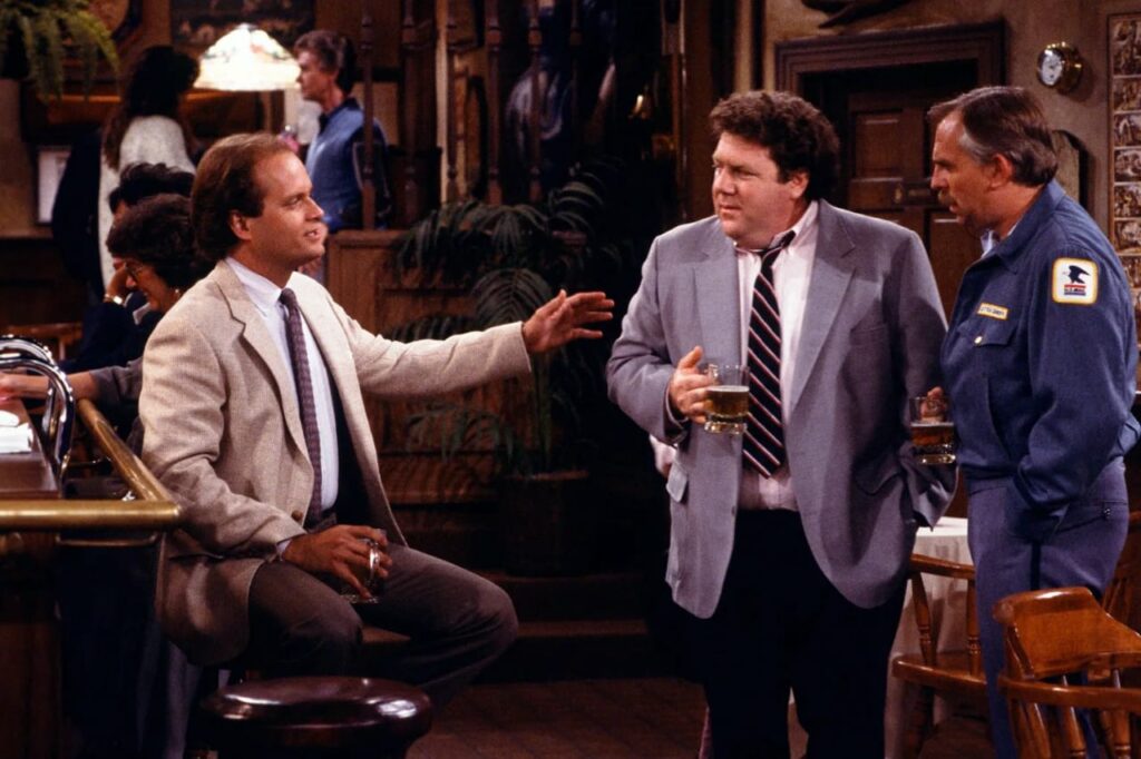 Norm talking to his friends in a still from Cheers.
