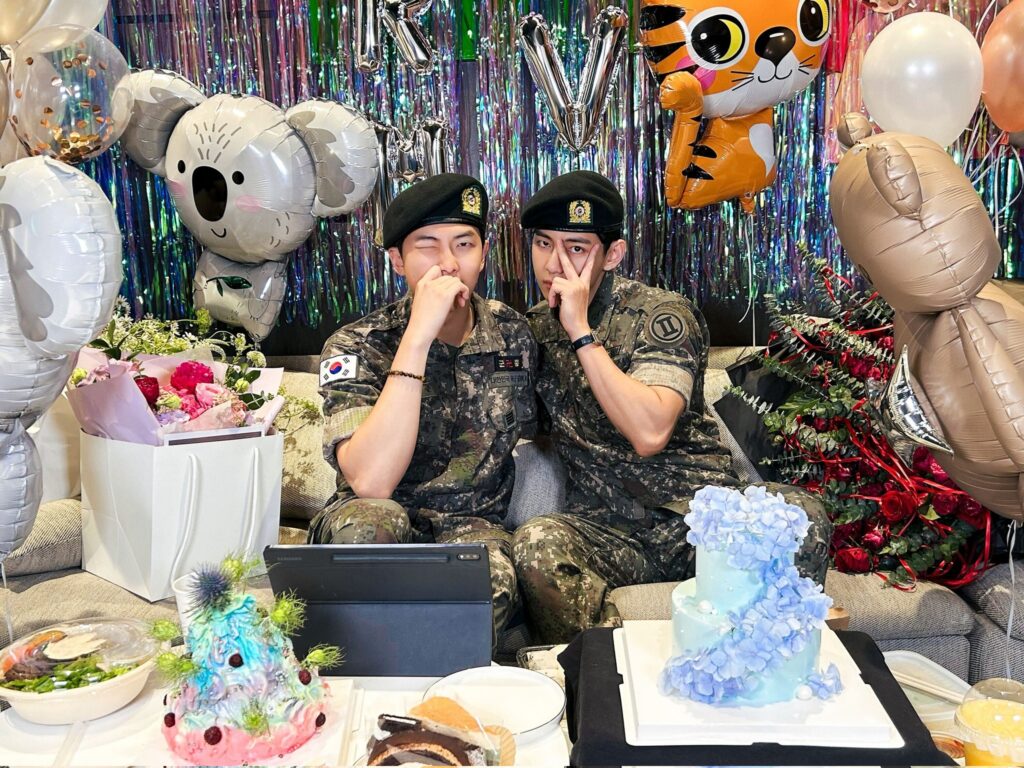 RM and V posing for a picture during a V-live following their military discharge
