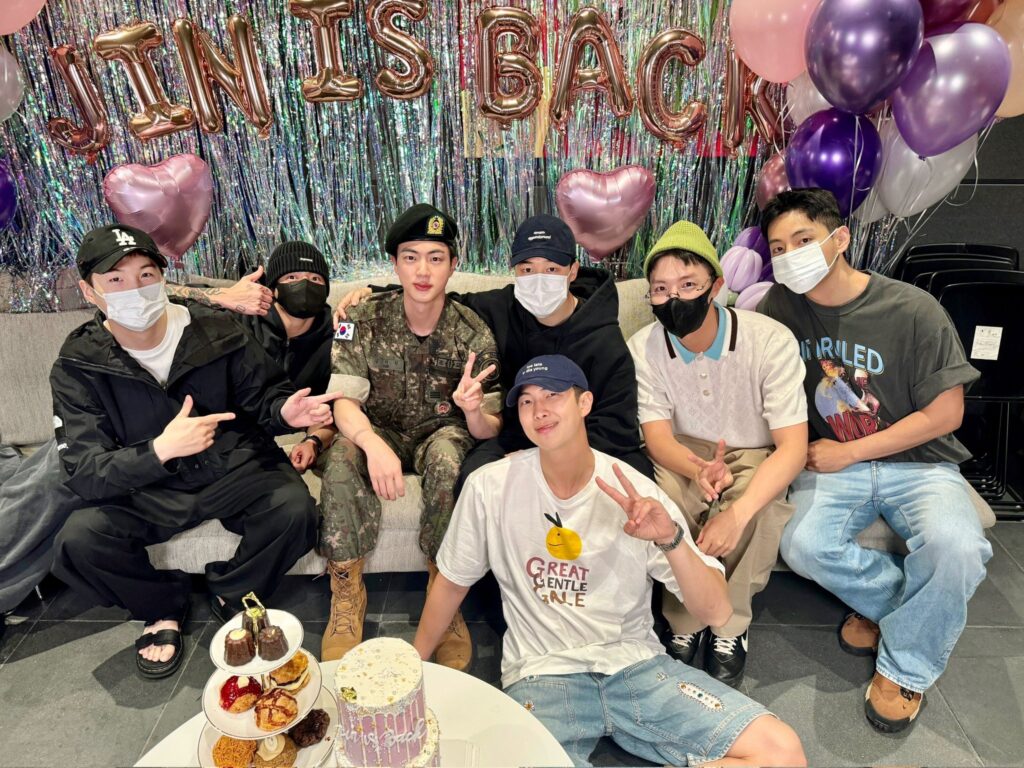 BTS members welcoming Jin back from the military with a small celebration