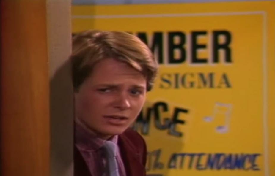 Michael J. Fox standing near a door in Family Ties.