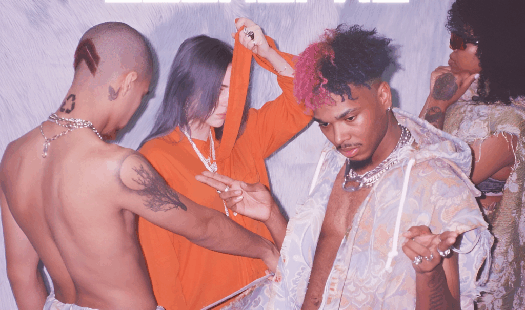 Billie Eilish Relationship History: All Her Boyfriends Before Nat Wolff 1 7:AMP's album "BLEAUPRO's" cover with Billie Eilish in an orange outfit in the center and him at the front with two other people in the background.