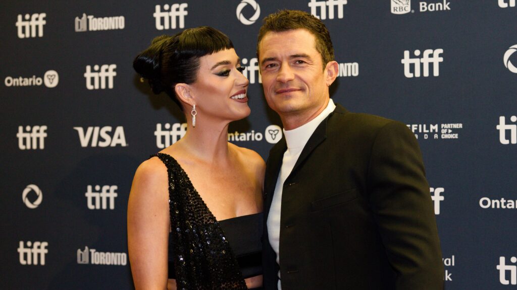 Orlando Bloom’s Relationship With Katy Perry: What Went Wrong 3 Katy Perry and Orlando Bloom at the Toronto International Film Festival (TIFF). Perry is wearing a black one-shoulder gown with sequined details and has her hair in an updo, while Bloom is in a black suit. They are posing affectionately together on the red carpet, with Perry leaning toward Bloom.