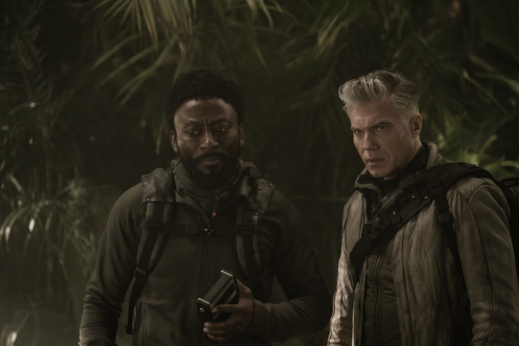 A still from Star Trek: Strange New Worlds Season 3 featuring M'Benga and Pike standing in a dark room