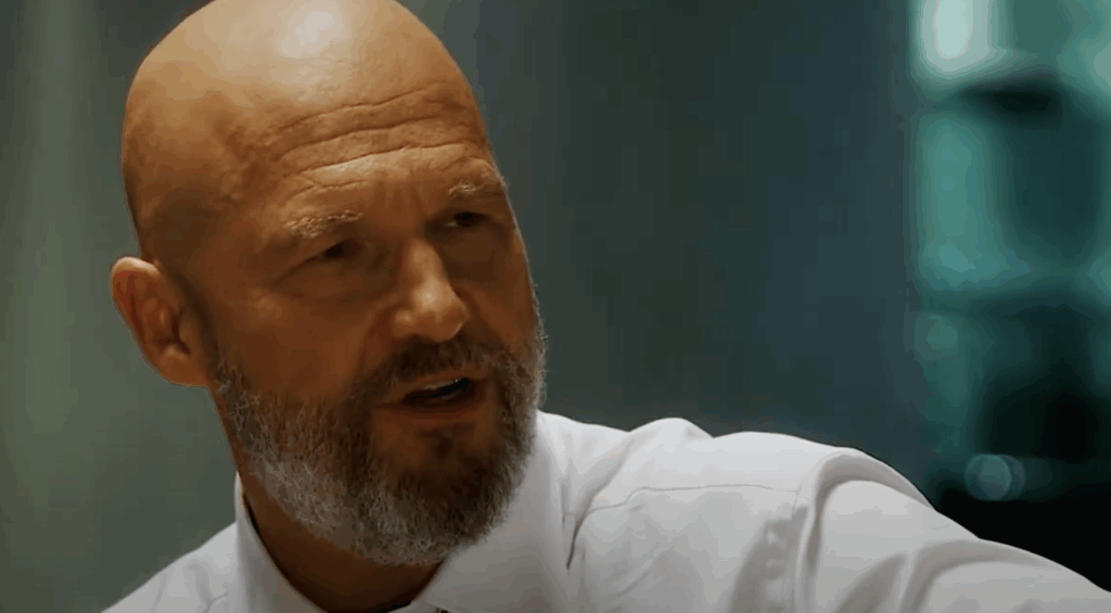 This Mystery Character in Ironheart Looks Like the Son of Robert Downey Jr’s Iron Man Villain 1 Jeff Bridges in a white shirt, and full beard.