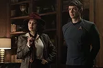 A still from Star Trek: Strange New Worlds Season 3 featuring La'an, dressed in a 1960s detective outfit, and Spock, dressed normally.
