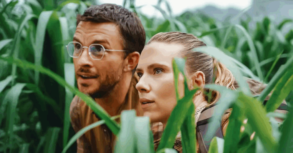 Jonathan Bailey and Scarlett Johansson hiding in the grass in Jurassic World Rebirth.