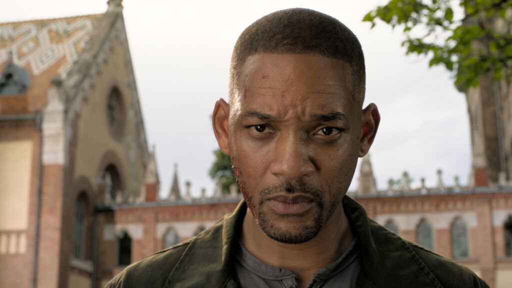 Will Smith with a shaved head looking serious in a still from Gemini Man.