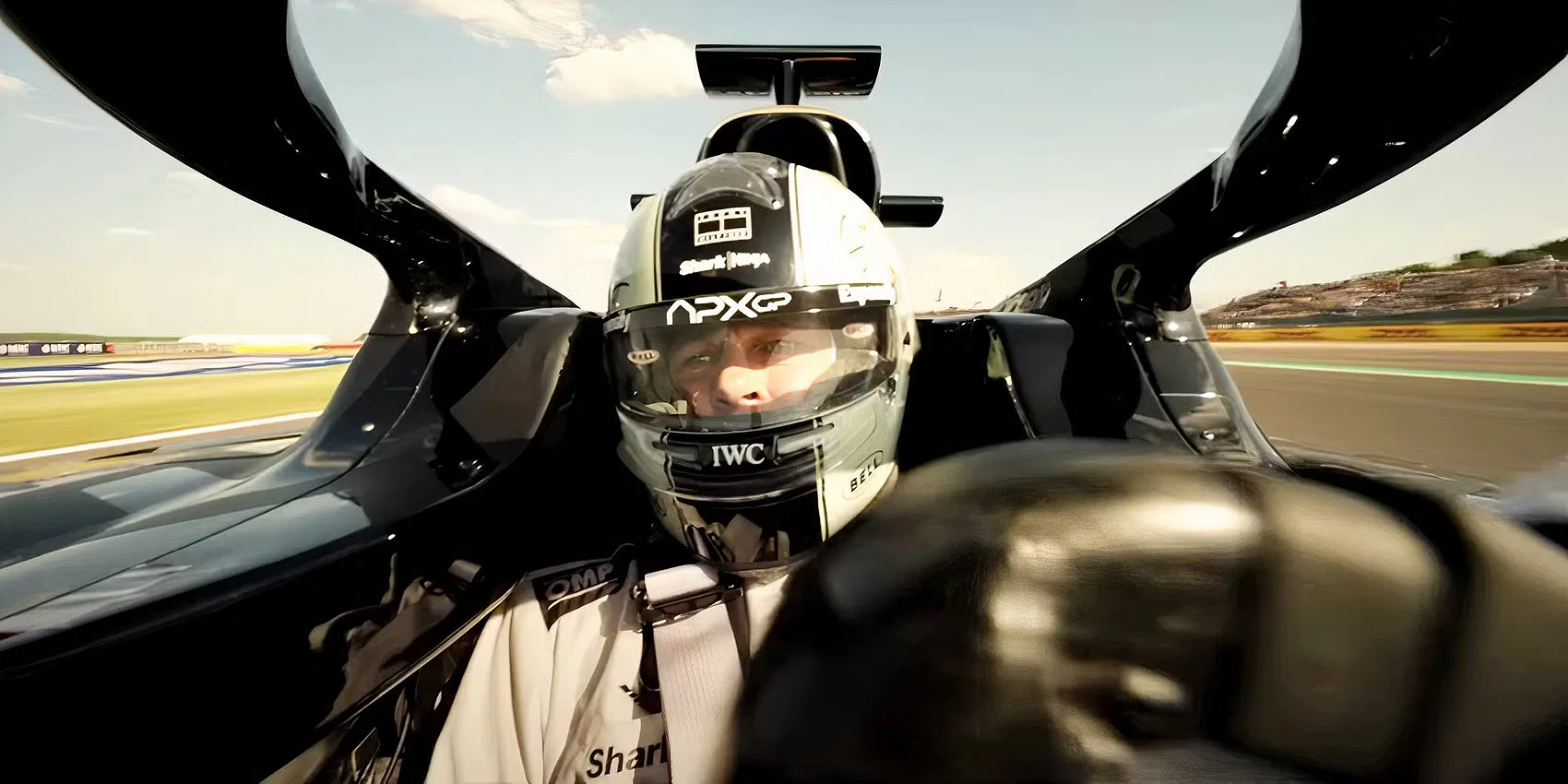 Sonny Hayes taking a turn while looking to his right in an F1 car in F1