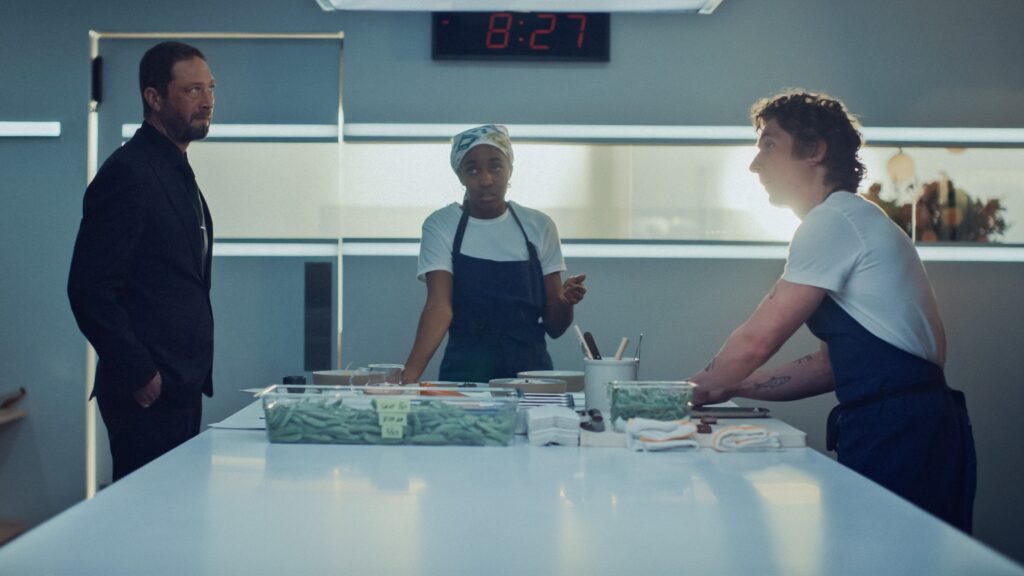People talk in a kitchen.