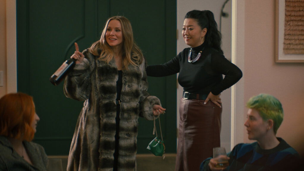Kristen Bell wearing a furcoat and pointing her finger in Nobody Wants This.