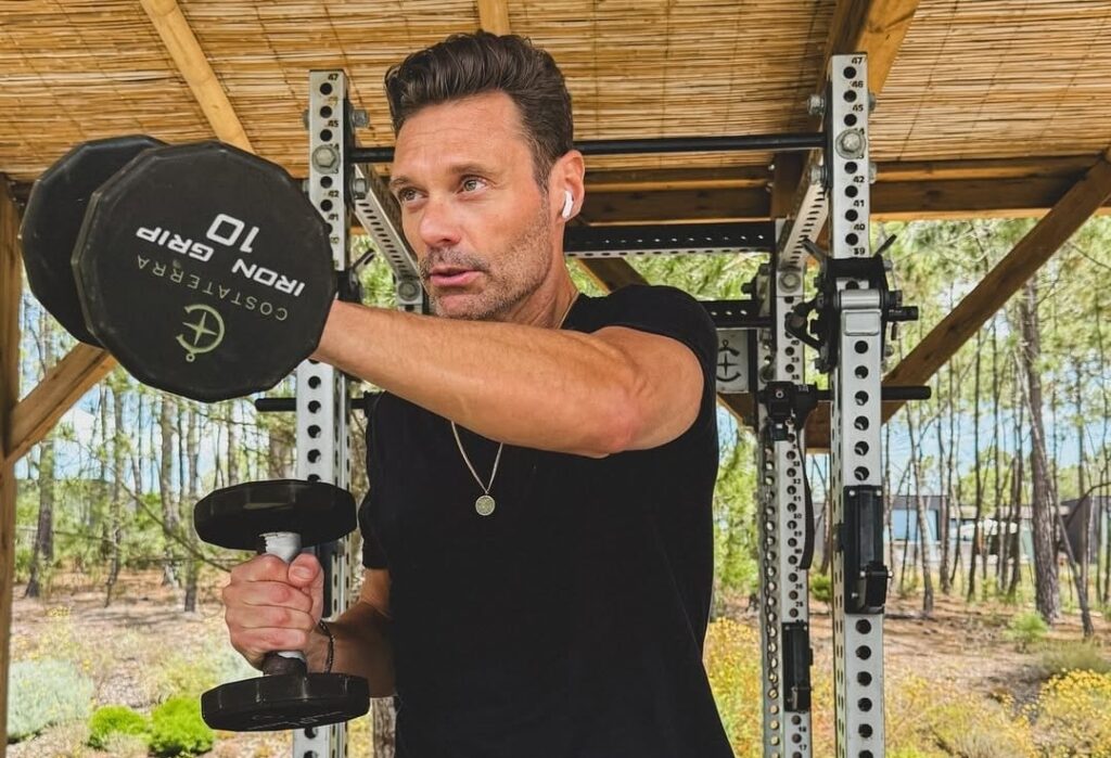 ryan Seacrest working out with dumbbells