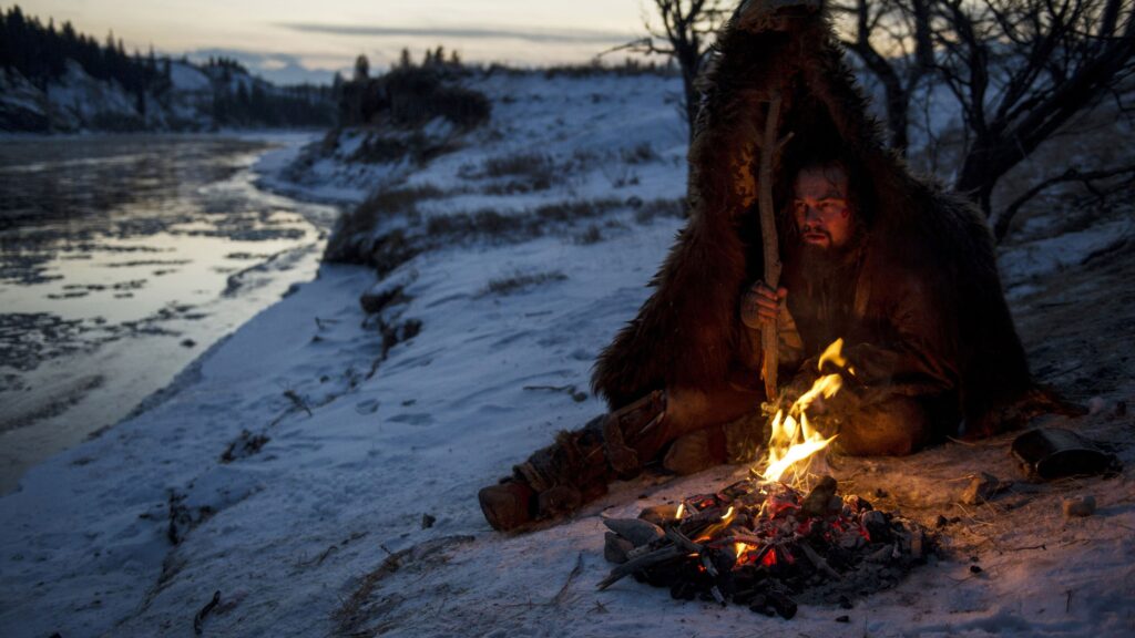 Hugh Glass (Leonardo DiCaprio) struggles to stay warm during a vicious winter - The Revenant
