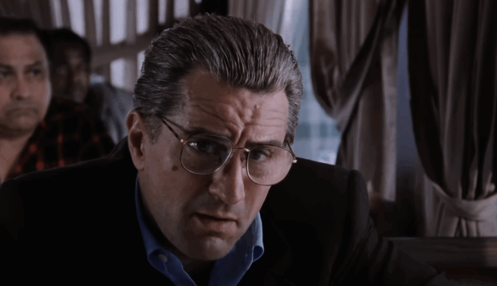 Robert De Niro, wearing glasses and sitting in a Diner in Goodfellas. 