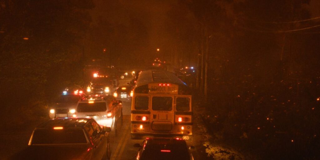 'The Lost Bus' on Apple TV+: Release Date, Cast, Plot, and All You Need to Know 3 A Scene from The Lost Bus with cars, buses, and other vehicles stuck on a road amid a raging wildfire