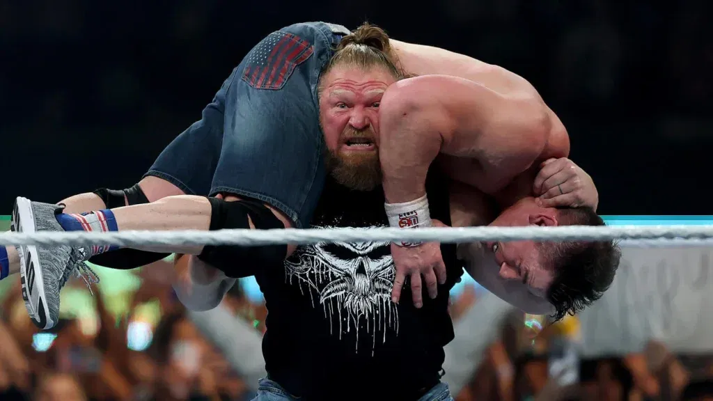 Brock Lesnar lifts up John Cena.