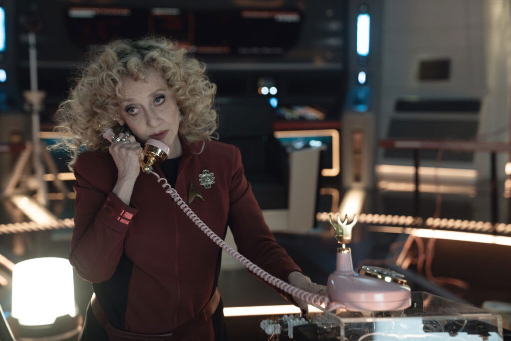 A still from Star Trek: Strange New Worlds Season3 featuring Pelia talking on a 20th century landline phone.