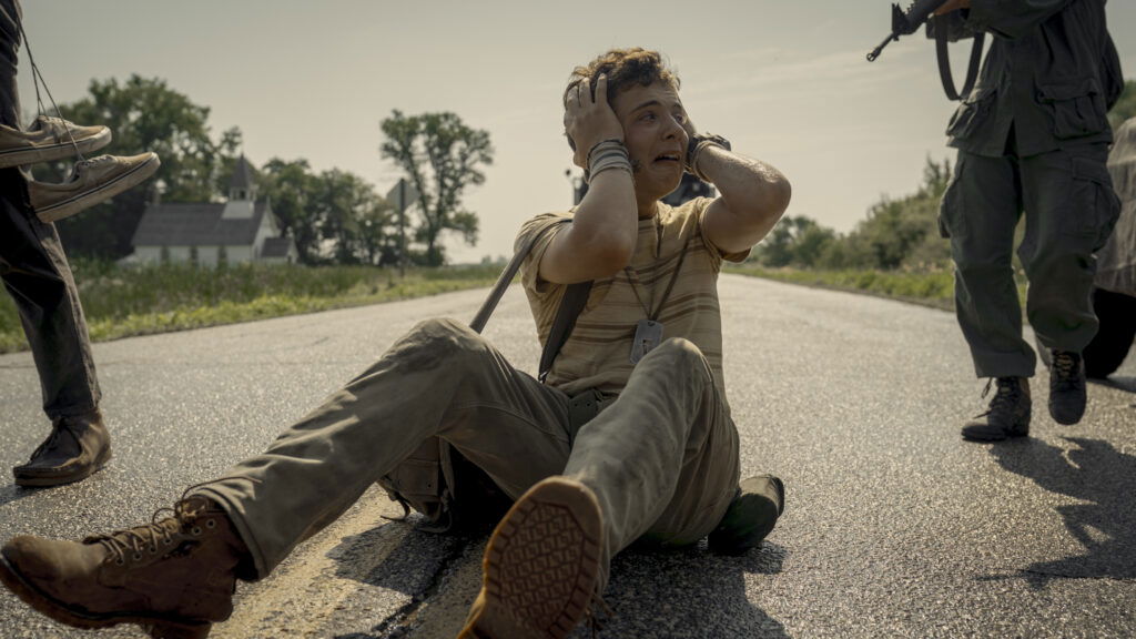 A character sitting and having a breakdown in The Long Walk