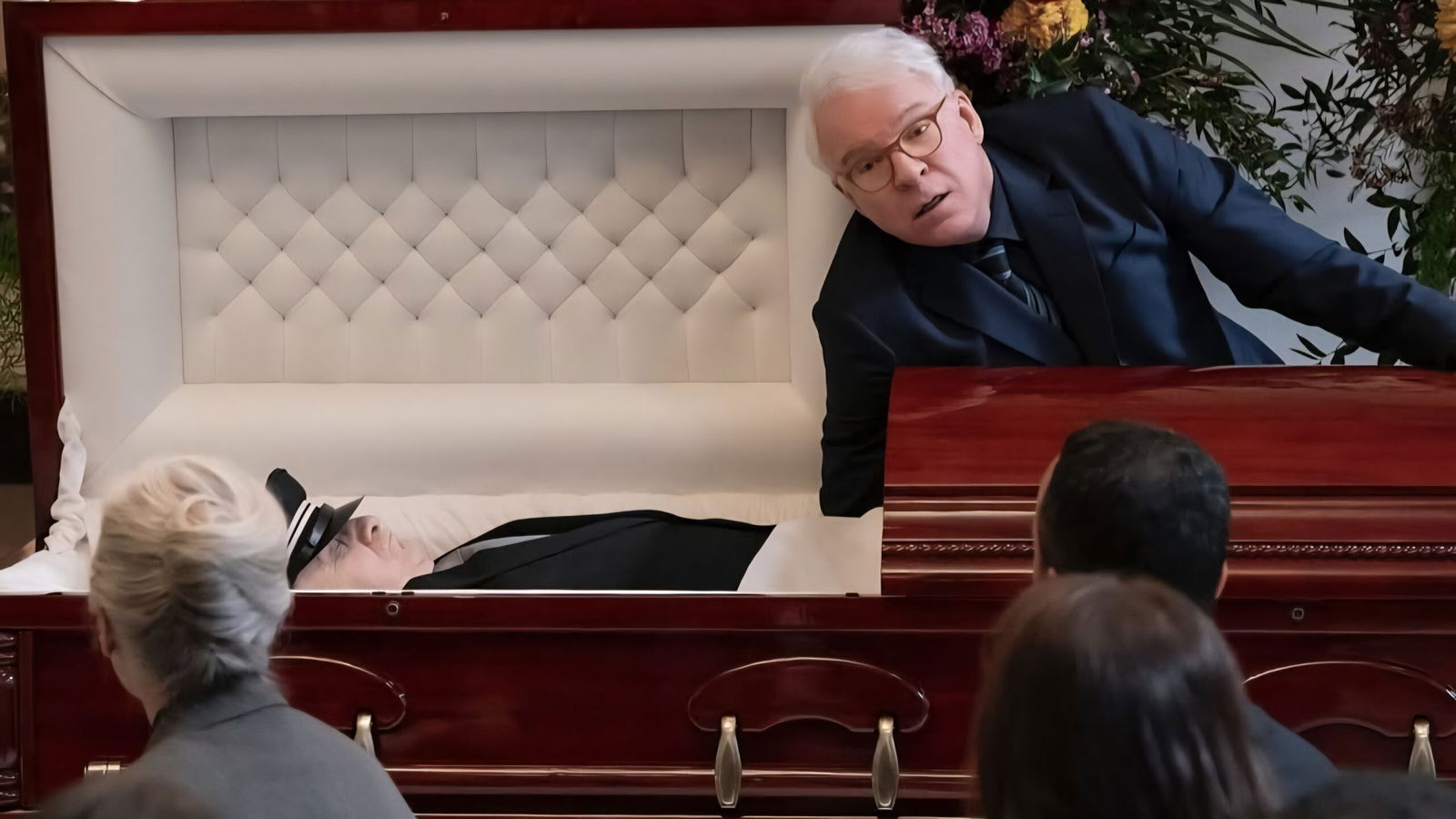 A man puts his has hand in a casket