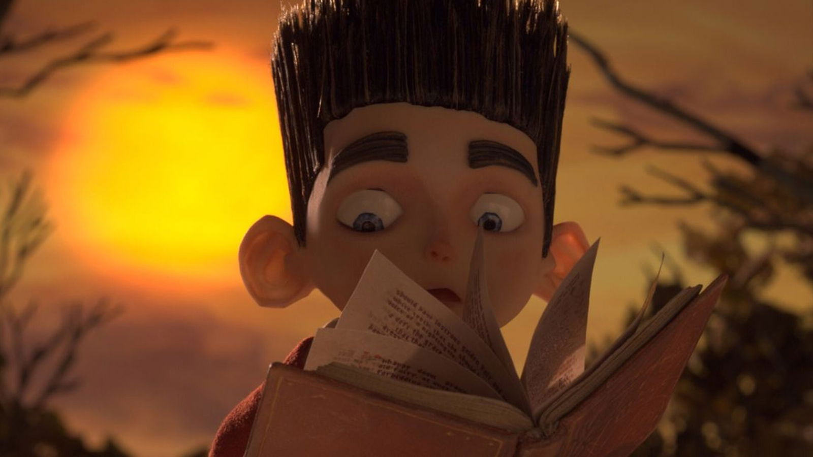 A close-up of Norman reading a book, with warm golden lighting creating a cozy atmosphere.