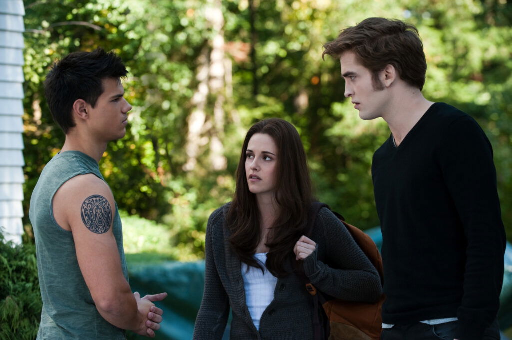 Edward and Jacob are staring at each other and Bella is in the middle
