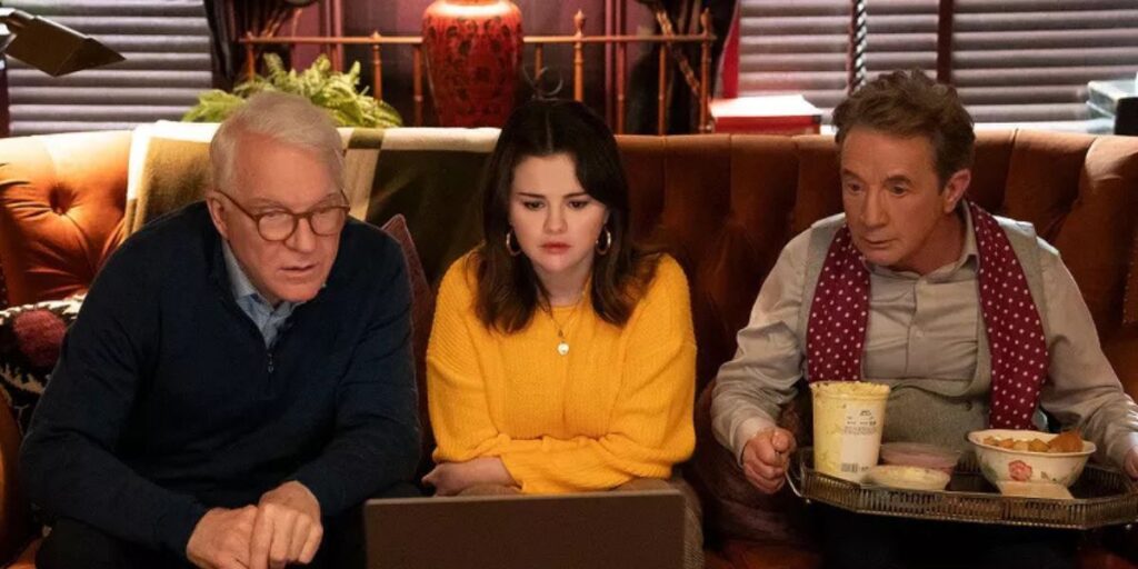 Selena Gomez, Martin Short, and Steve Martin in Only Murders in the Building sitting on a sofa side-by-side and looking at a computer screen