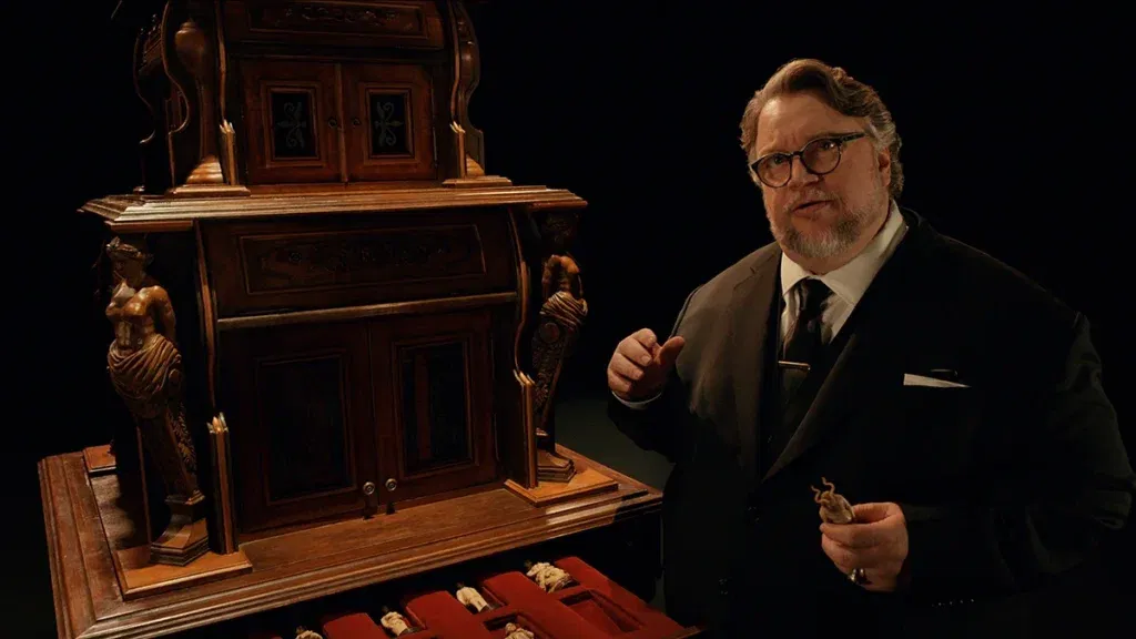 Guillermo del Toro standing near a cabinet