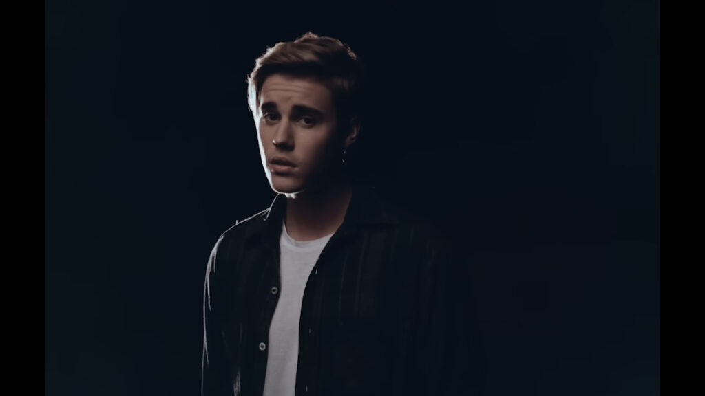 Justin Bieber is looking with a emotional expression