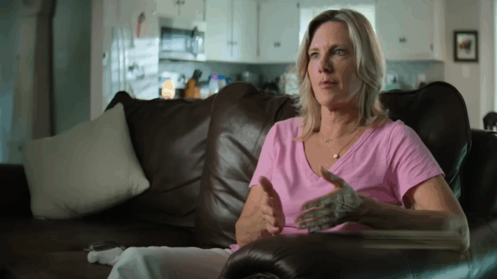 A woman in a pink t-shirt sitting on a couch in love con revenge