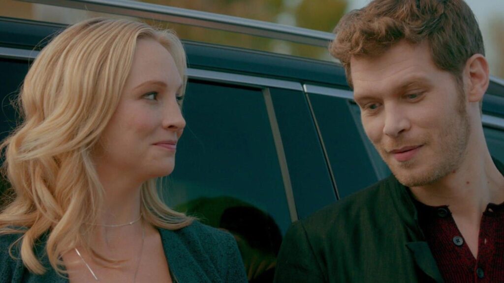 Caroline and Klaus in an intimate moment, with Klaus leaning close to Caroline as she looks up at him.