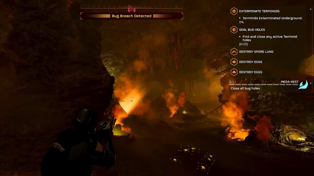 Helldivers 2 gameplay screenshot featuring a player aiming at a Bile Titan hole inside a cave.