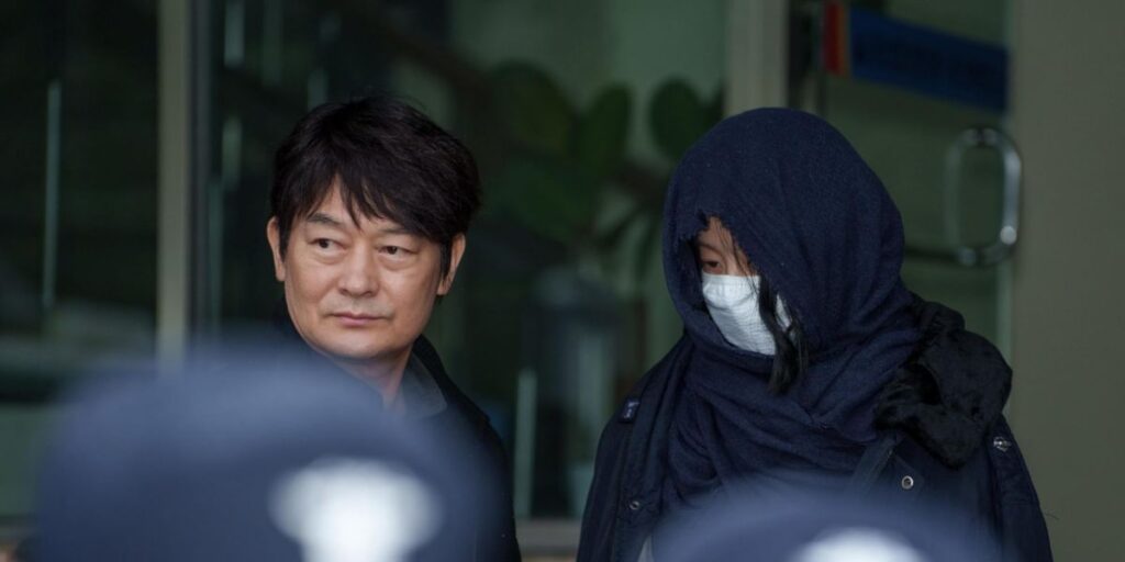 Jo Sung-ha and Ko Hyun-jung with the latter covered with a blue cloth and jacket.
