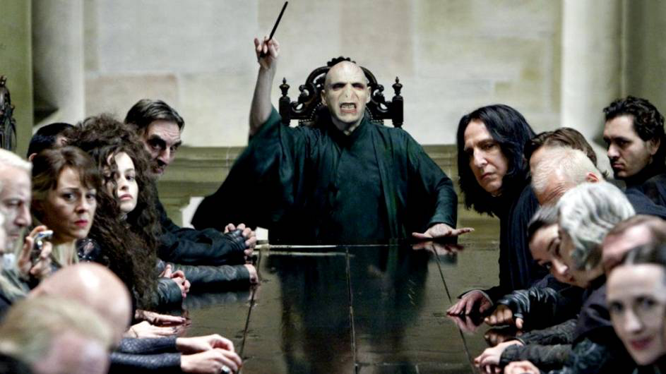 Voldemort with his close Death Eaters at a dinning table.