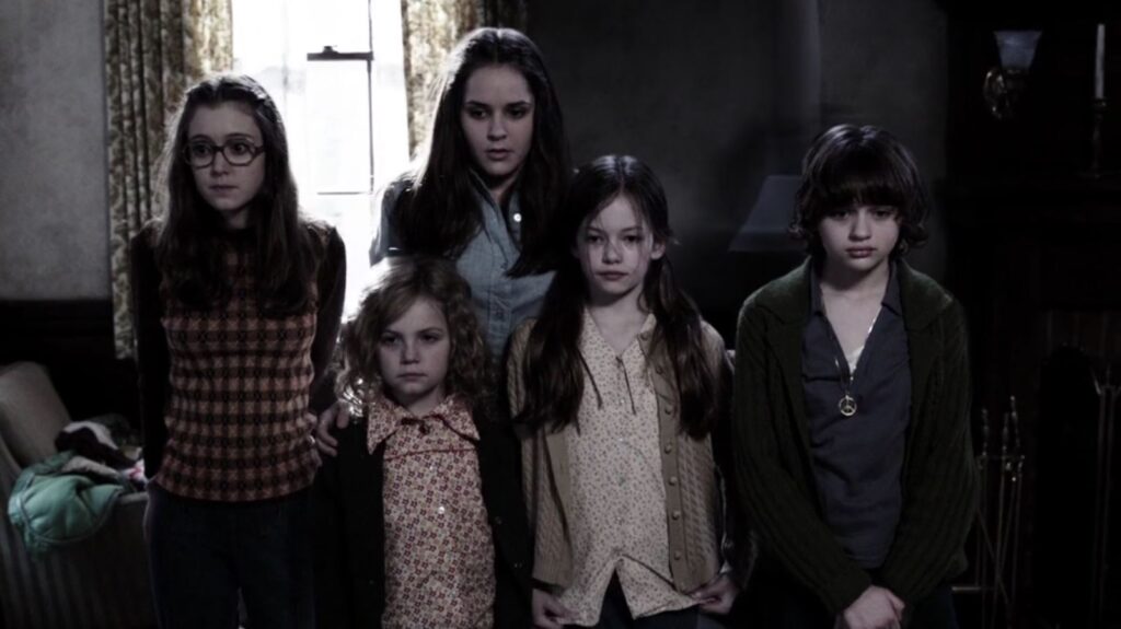 The Perron children standing in a still from The Conjuring.