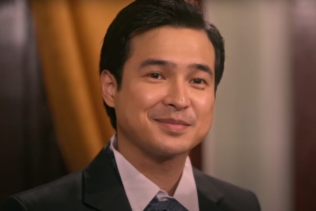 A man in a suit smiling