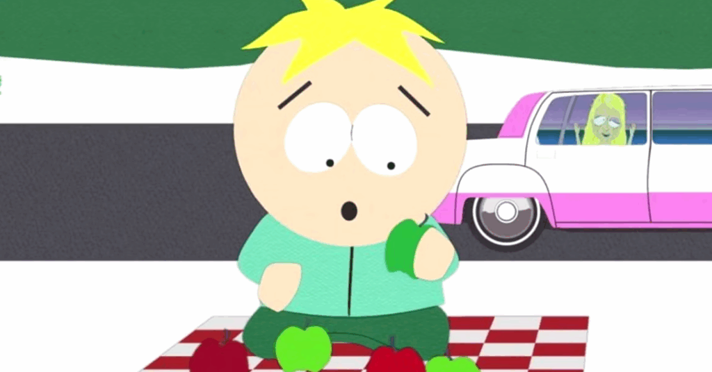 Butters is sitting on a picnic blanket with red and green apples scattered around him, looking worried. In the background, a pink limousine is driving.