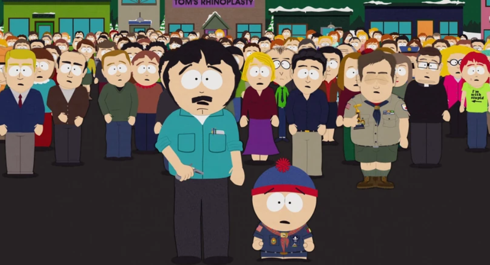 Randy and Stan Marsh, with serious expressions on their faces are standing in front of a very large crowd of people.