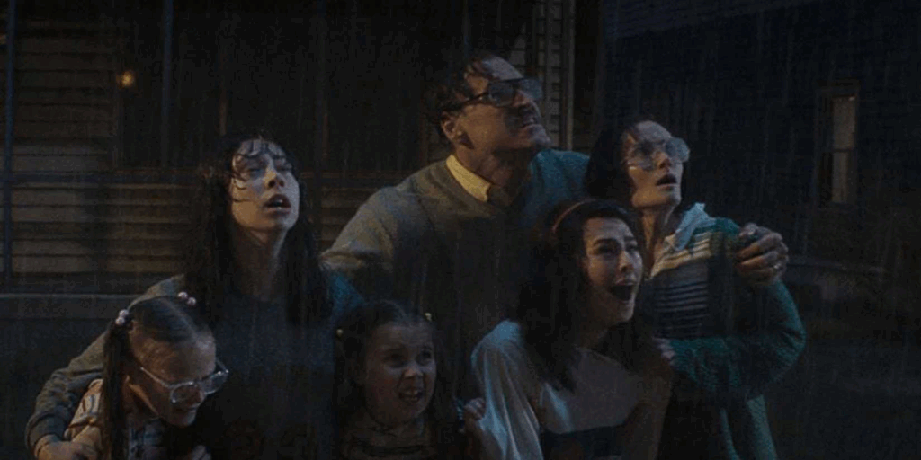 The Smurl family drenched in rain looking up at their house 