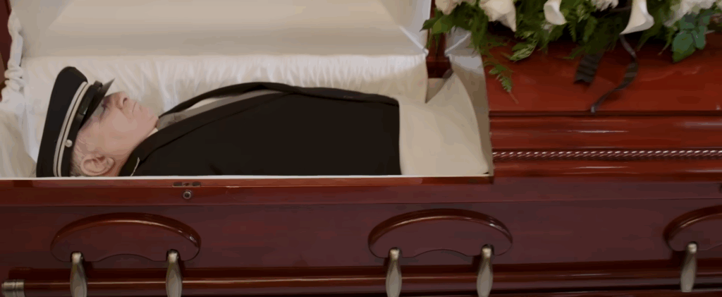 Lester lies in a coffin