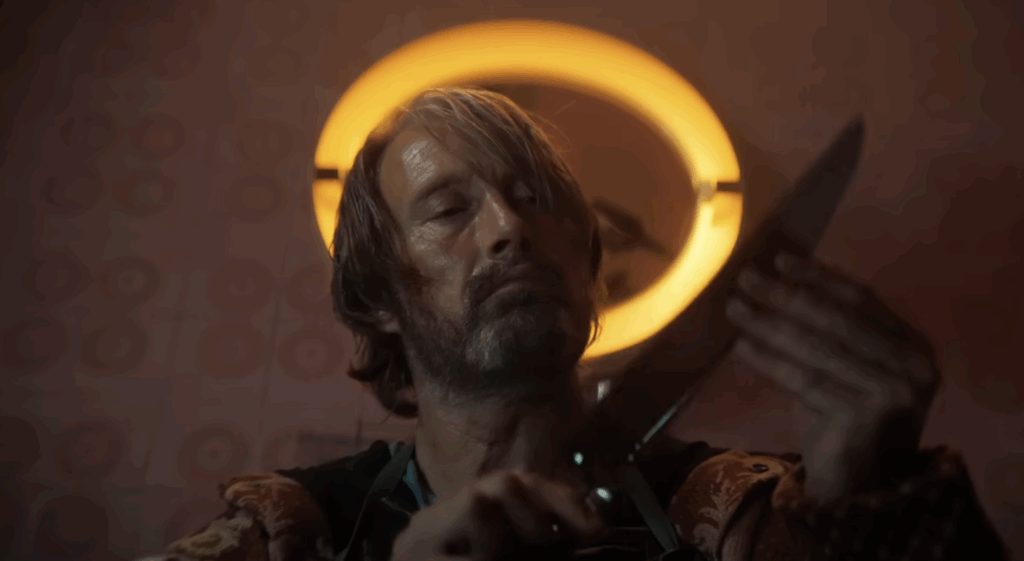Mads Mikkelsen, holding a knife in Dust Bunny. 